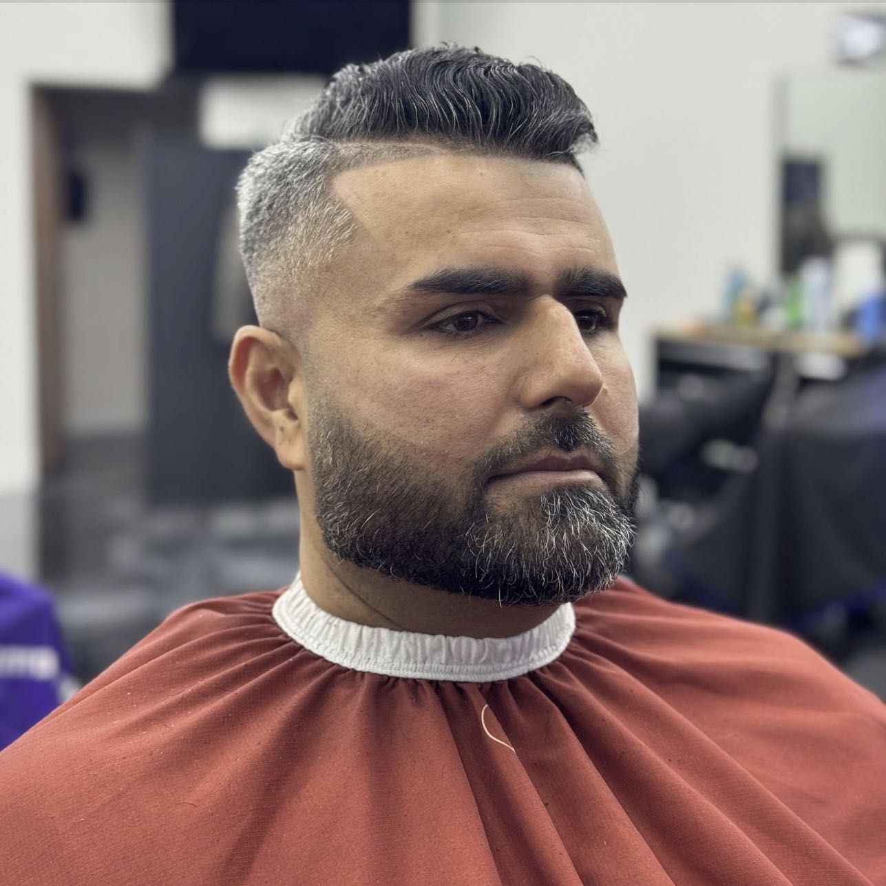 Silver fade and beard, rust cape.